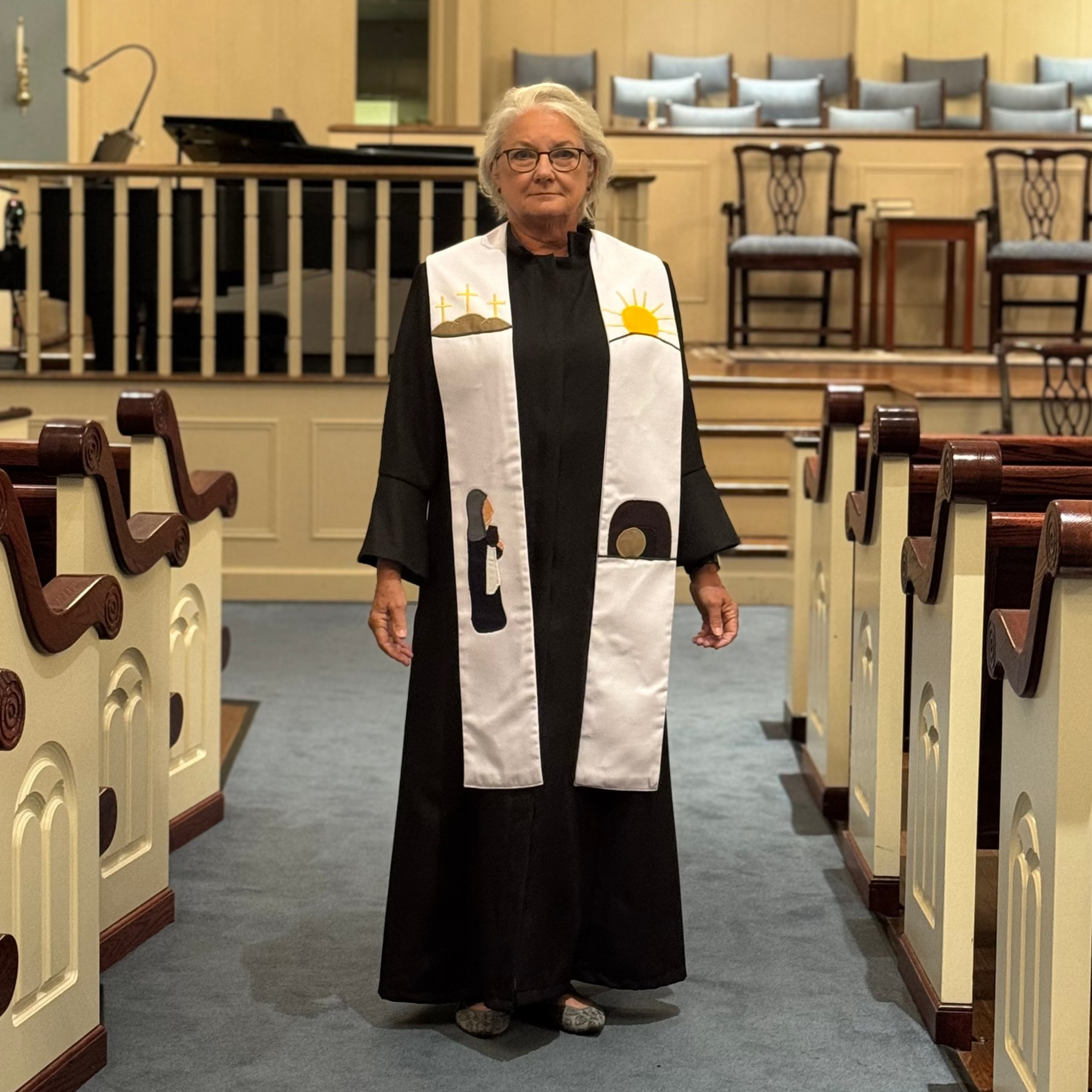 Person wearing a black robe with a white stole in a church setting